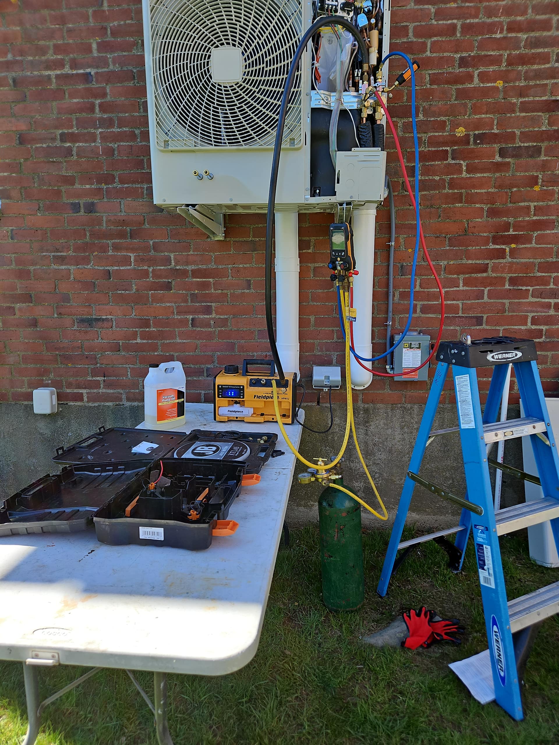 Aces Highlands technician tools and gauges during a heat pump installation at a Maine home